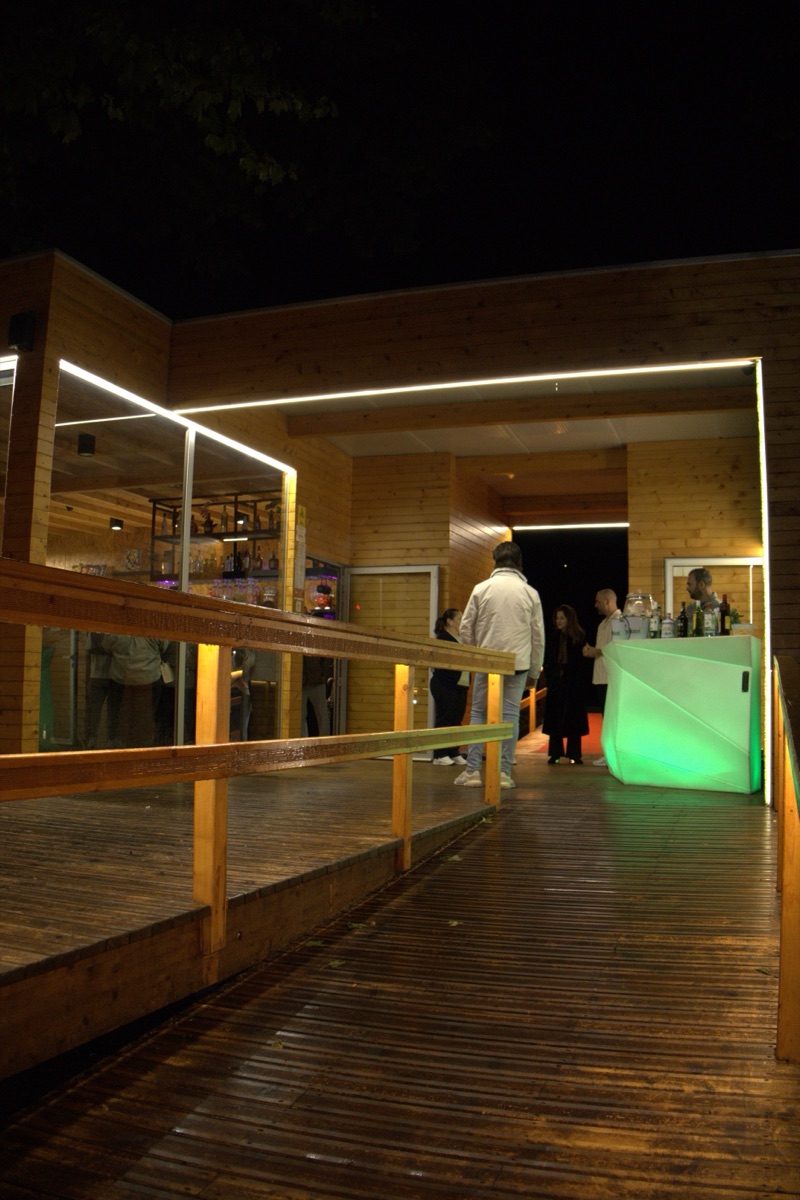 Pavilhão do Bar da Praia ao crepúsculo, estrutura de madeira a brilhar no parque